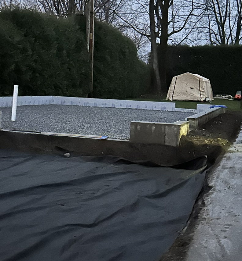 Residential foundation preparation with concrete footings and compacted stone